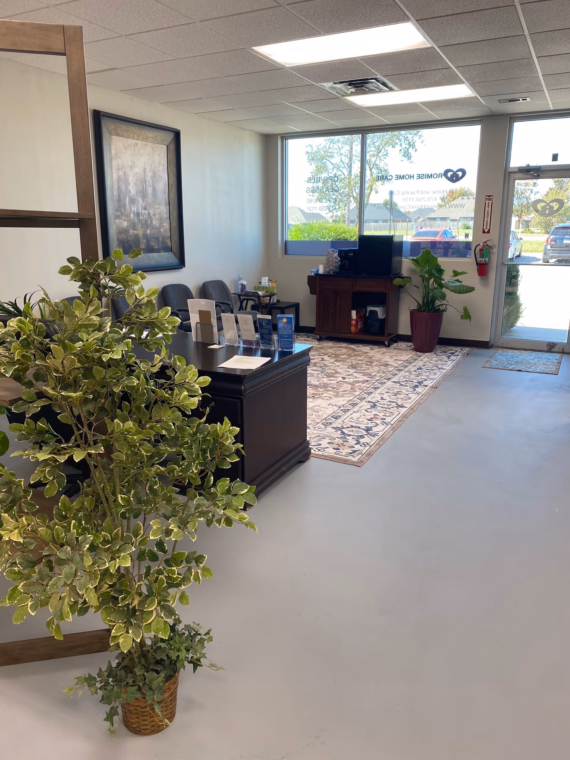 Senior living facility lobby with reception desk, seating, rug, and glass entrance.