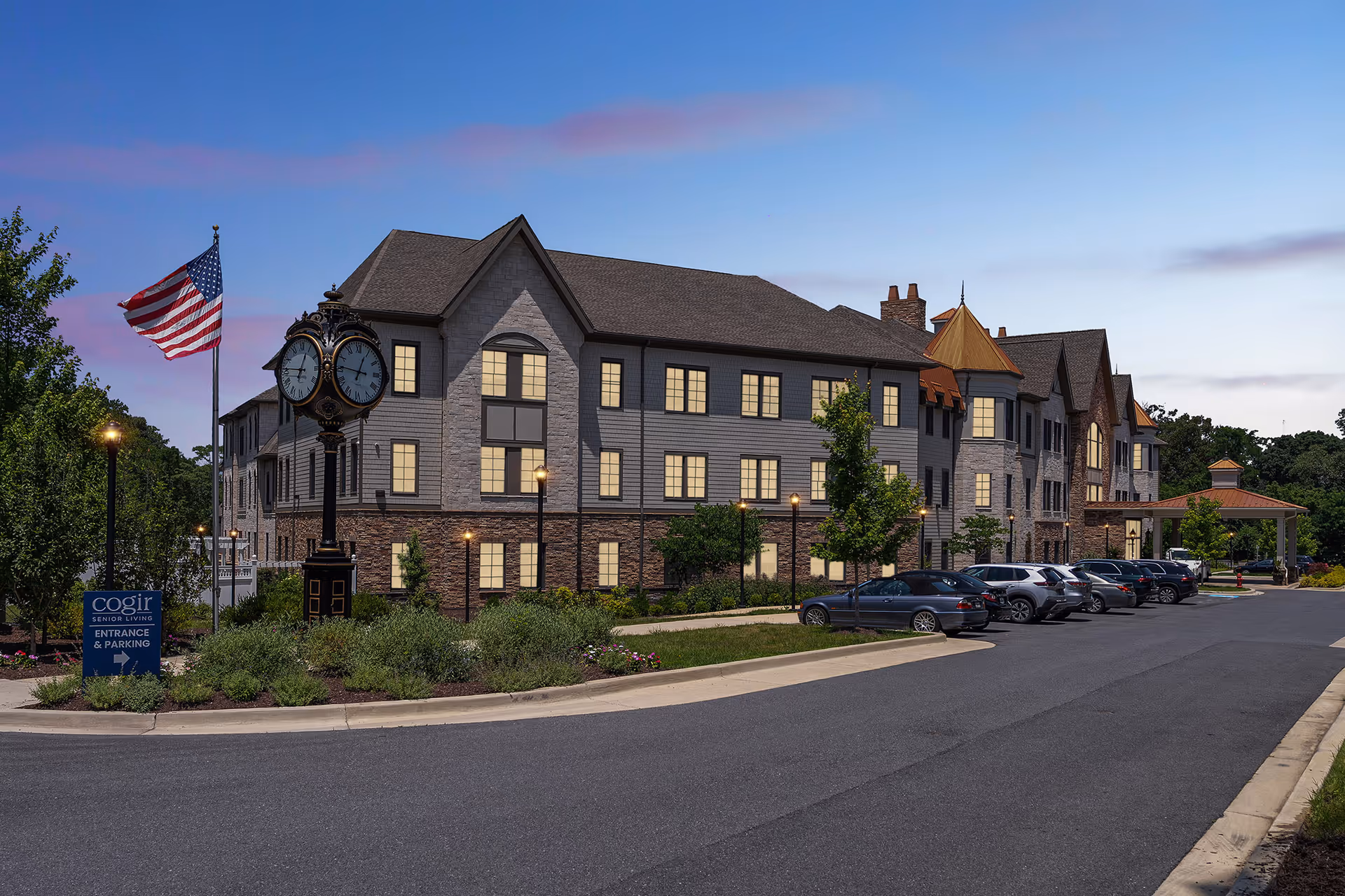 Exterior view of Cogir of Potomac senior living building, parking lot, flag, clock