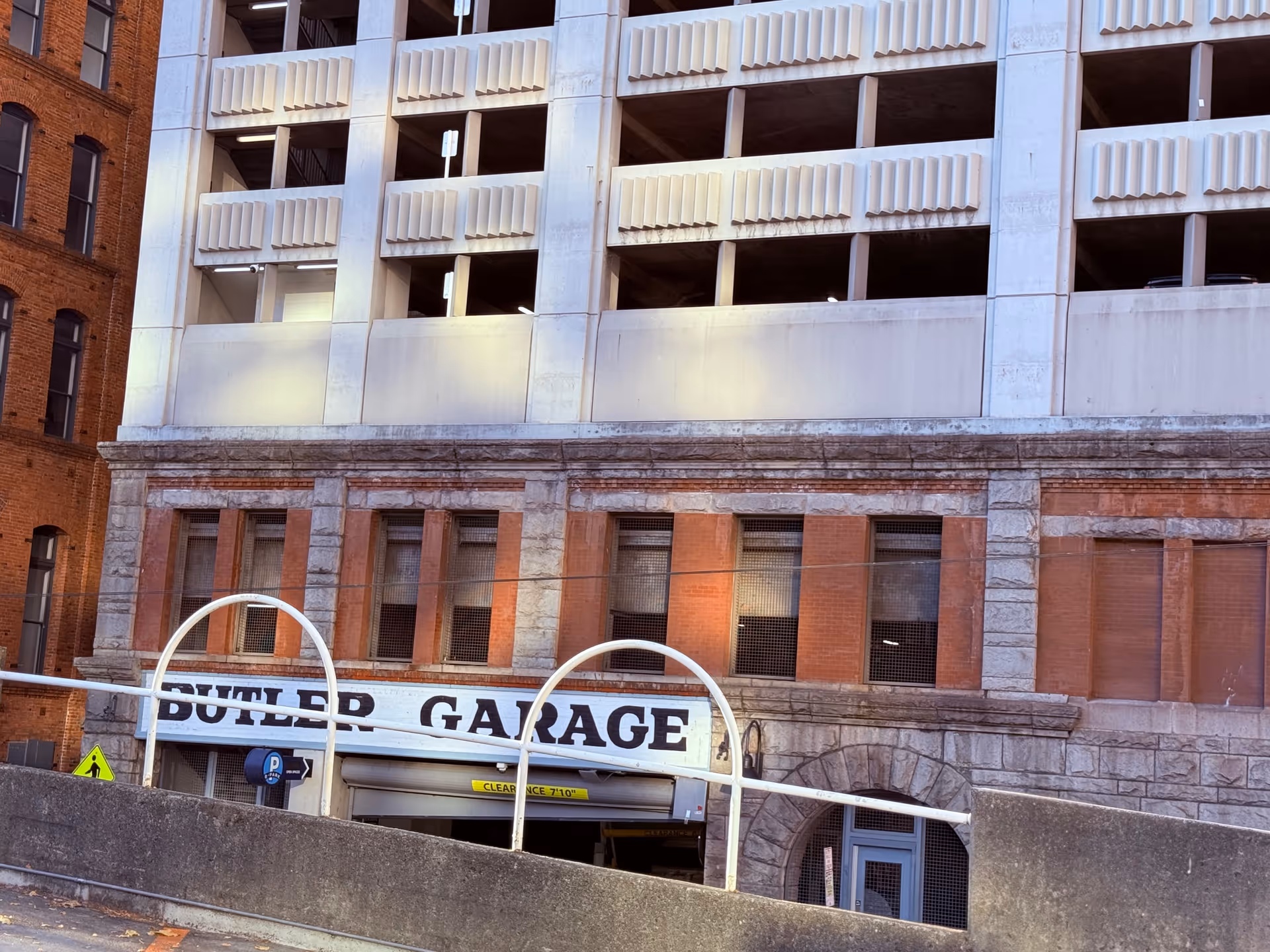 Exterior view of a brick building with a Butler Garage sign and parking entrance.