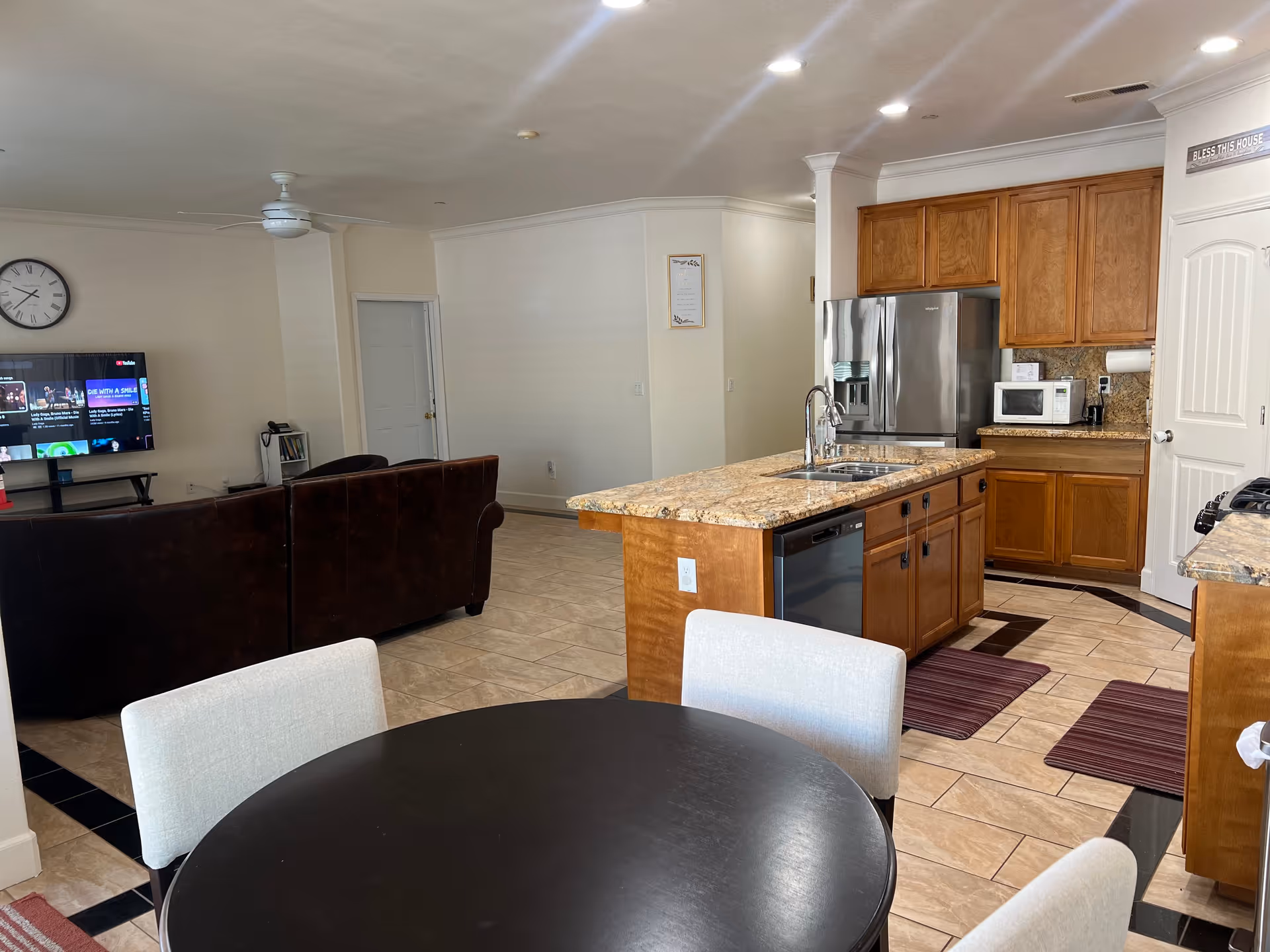 Open-concept living area with kitchen island, round dining table, and television.