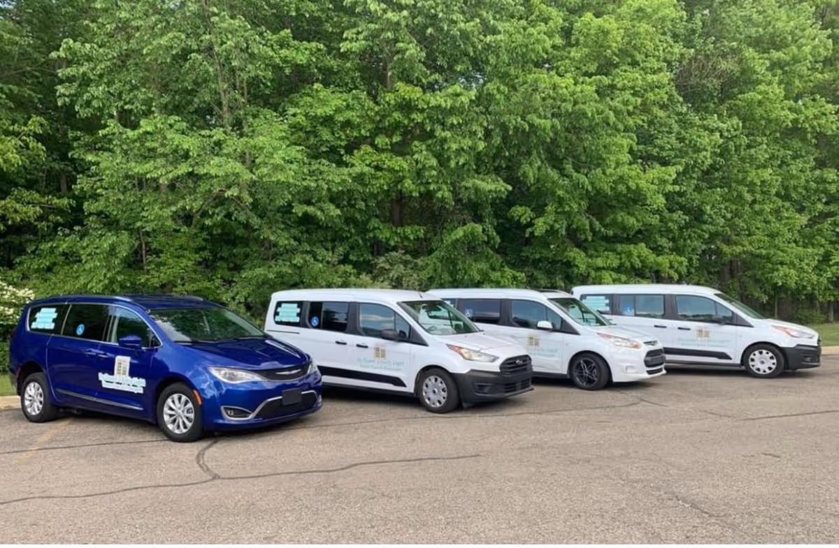 Line of branded vans for By Dawn’s Early Light Home Care Service parked in a lot