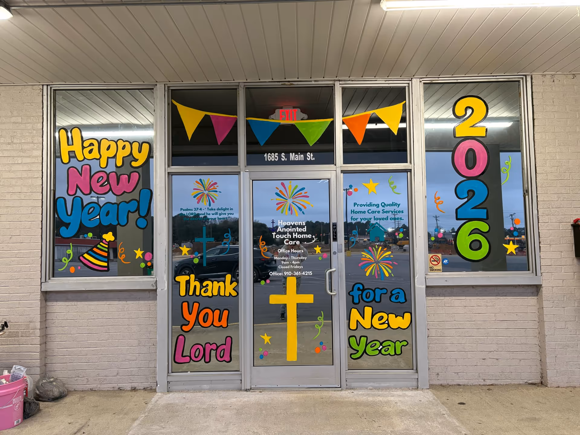 Front of a brick building with New Year decorations and Heavens Anointed Touch Home Care signage.
