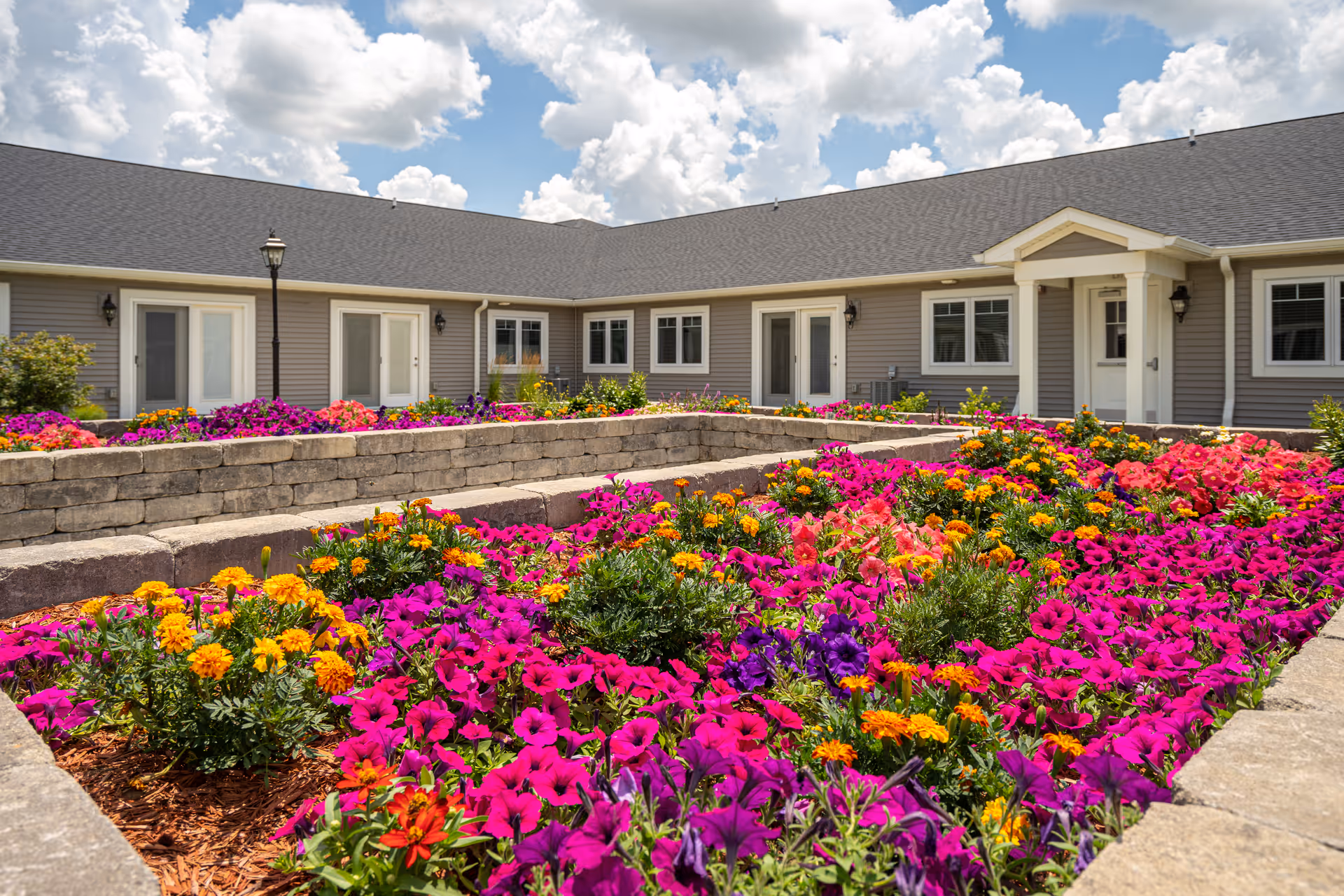 Front of Villas of Holly Brook Mt. Carmel with colorful flower beds around entrance.