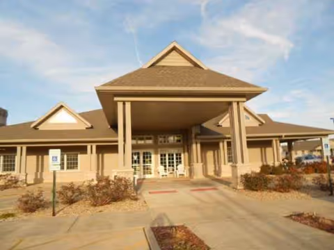 Front view of Rochester Estates Senior Living entrance with porte-cochere and parking lot.