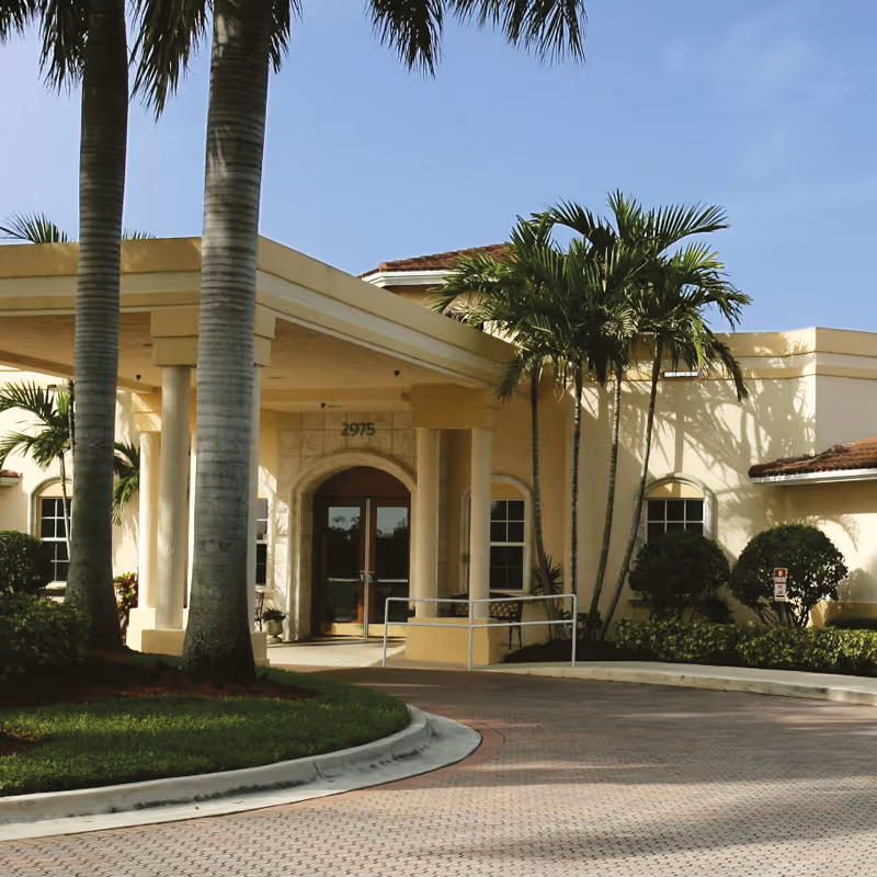 This image shows the HarborChase of Coral Springs entrance with palm trees.