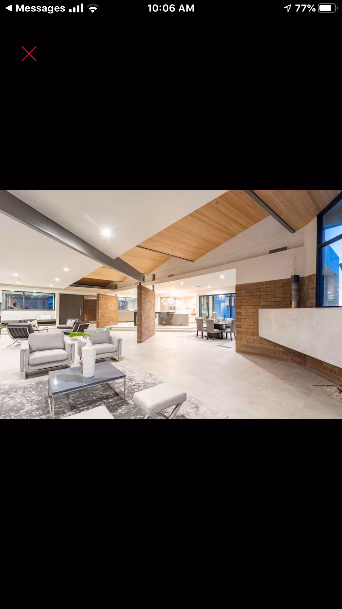 Open, modern senior living lounge with brick columns, wood ceiling, and bright seating.