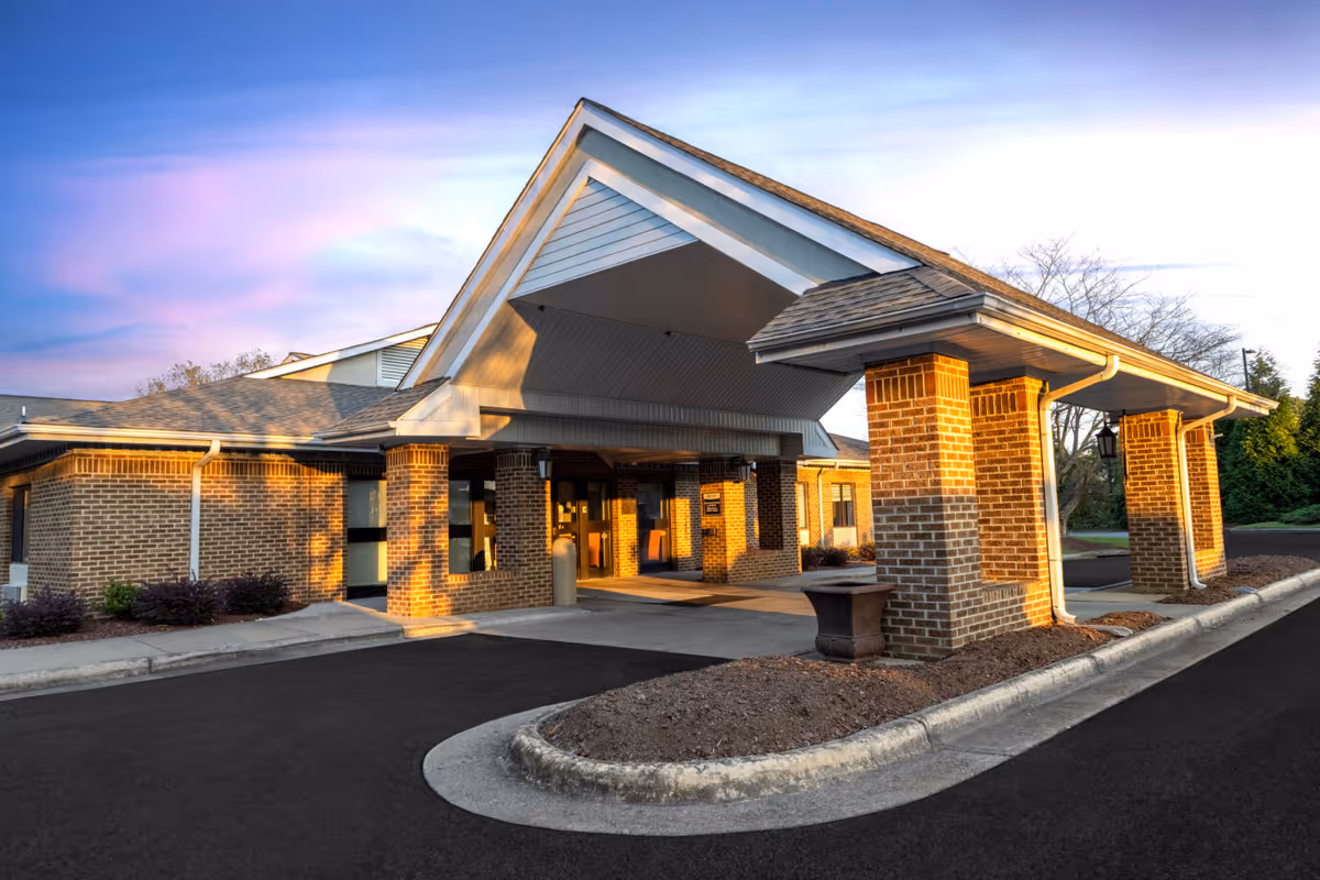 Front entrance of Brantwood NH & Retirement Center with brick columns and a covered driveway.
