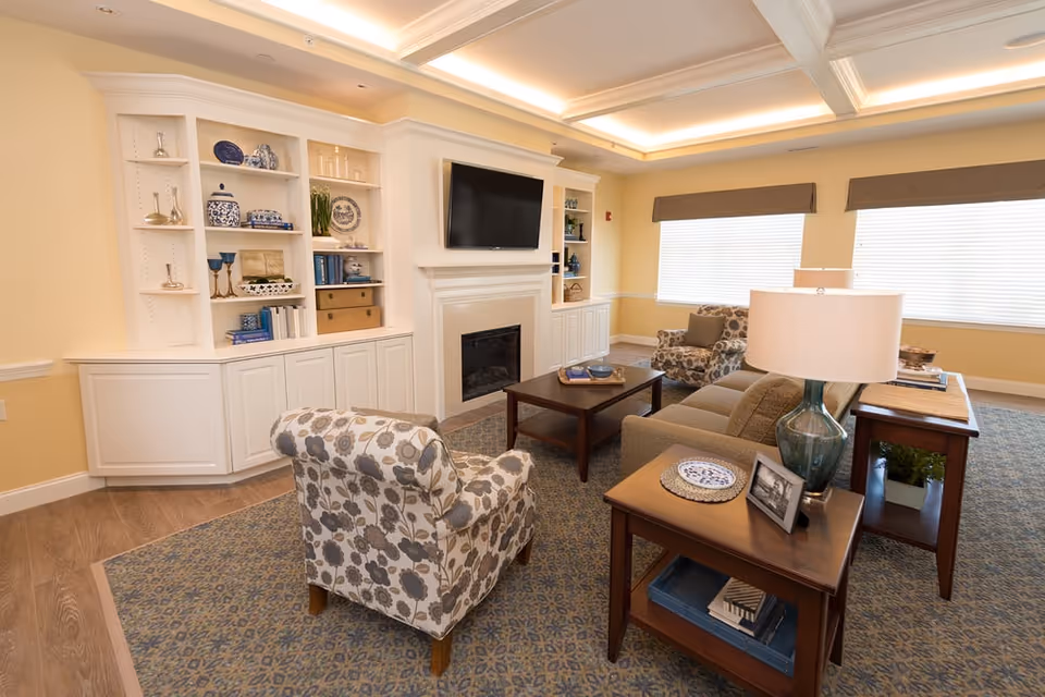 Bright living room with fireplace, built-in shelves, and seating in Beacon Square Living.