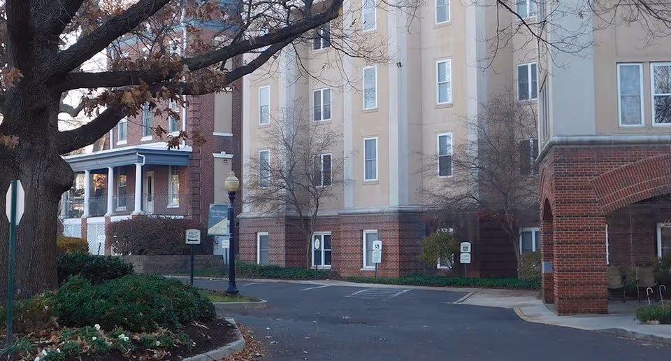 Exterior view of United Methodist Communities at Collingswood, showcasing the building, brick facade, and parking area.