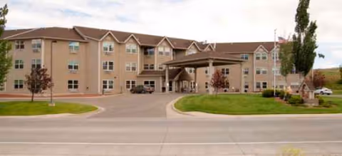 Exterior view of Cascades of Sugarland Ridge senior living facility with driveway and entrance.