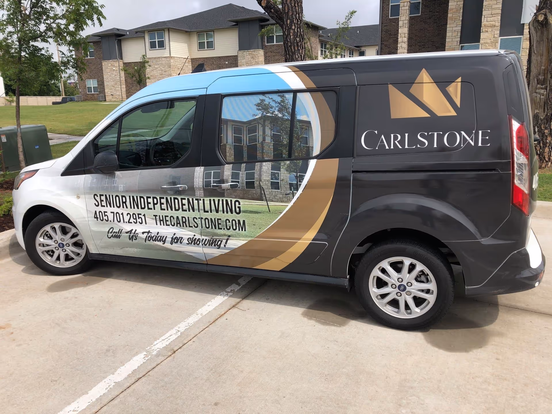 Carlstone Senior Independent Living branding on a dark van parked outside residential buildings.