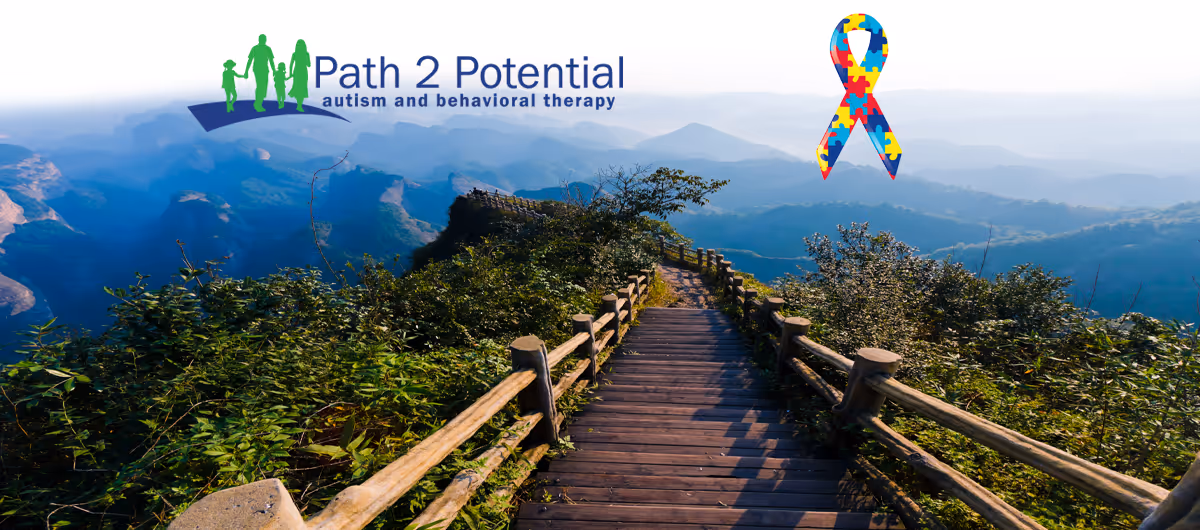 Outdoor mountain trail with wooden railings and a scenic blue valley backdrop.