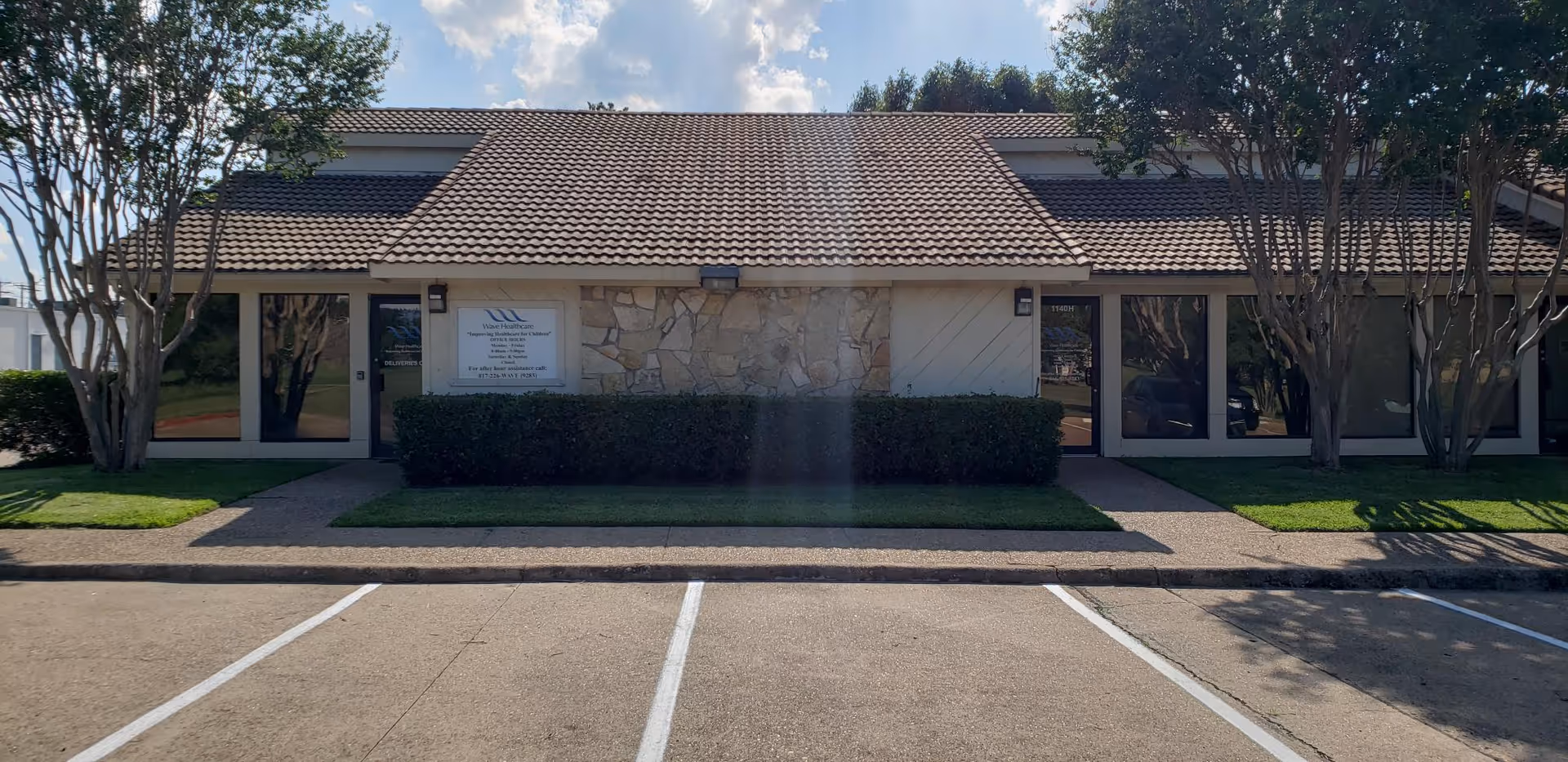 Front exterior of a single-story senior living building with brown tiled roof and landscaping.