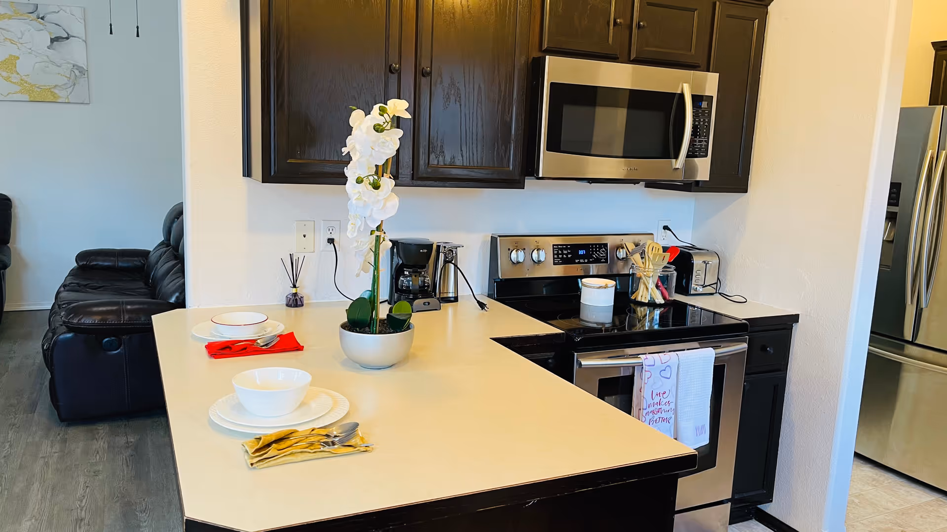Modern kitchen with dark cabinets, stainless appliances, and a center island in a senior living facility.