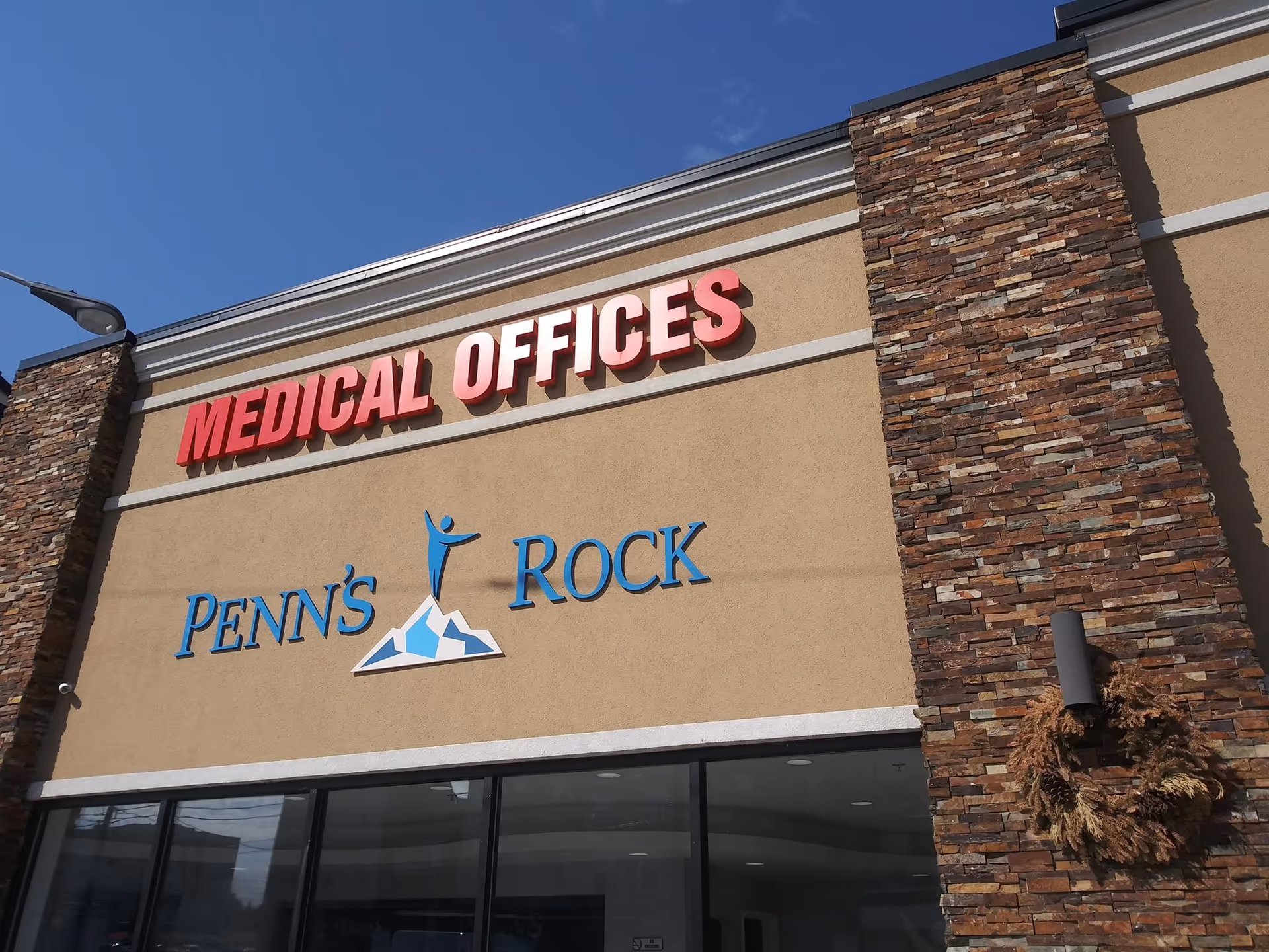 Front of a beige building with red Medical Offices sign and Penn's Rock logo