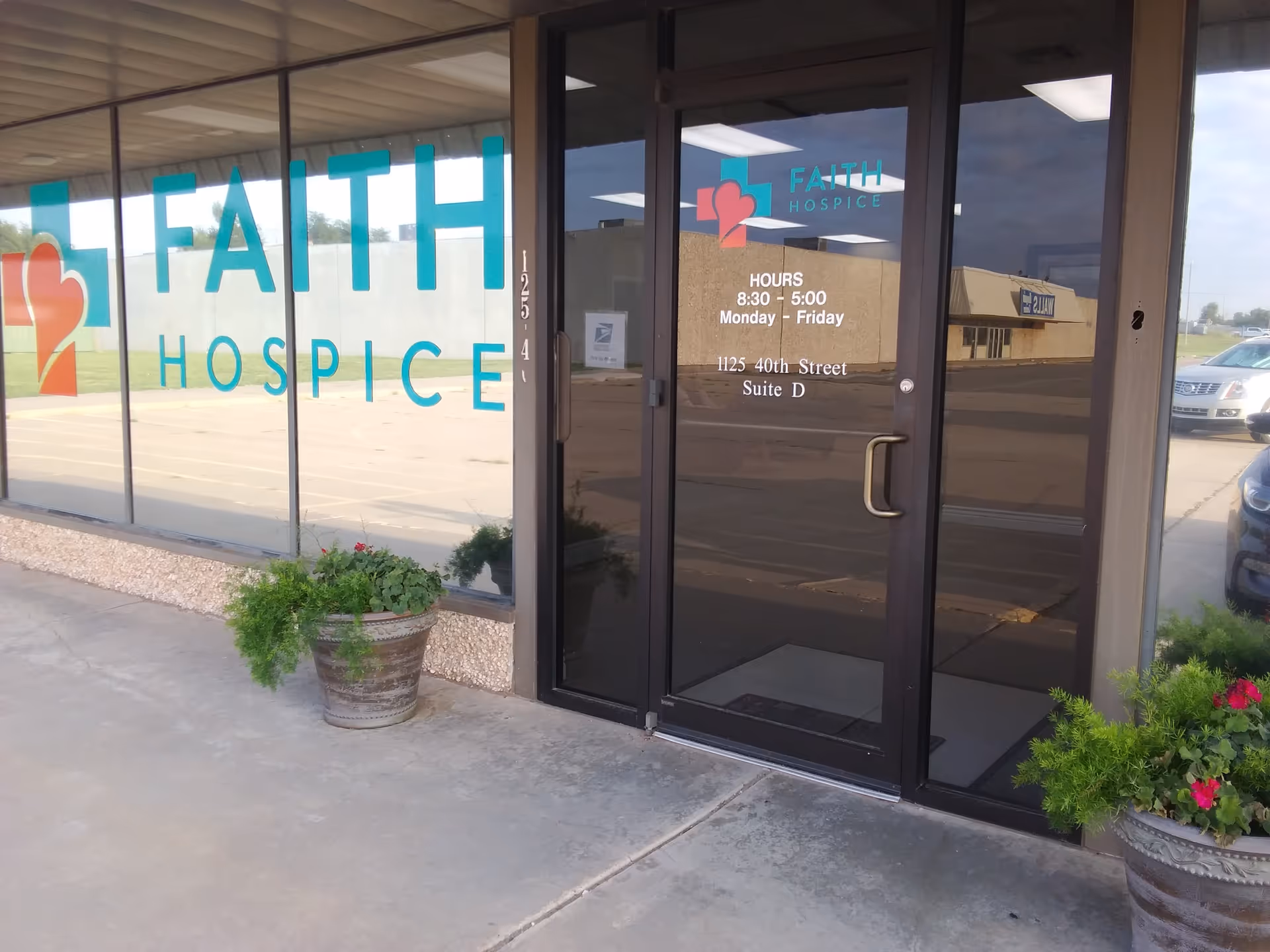 Glass storefront displaying Faith Hospice signage and a glass entrance door.