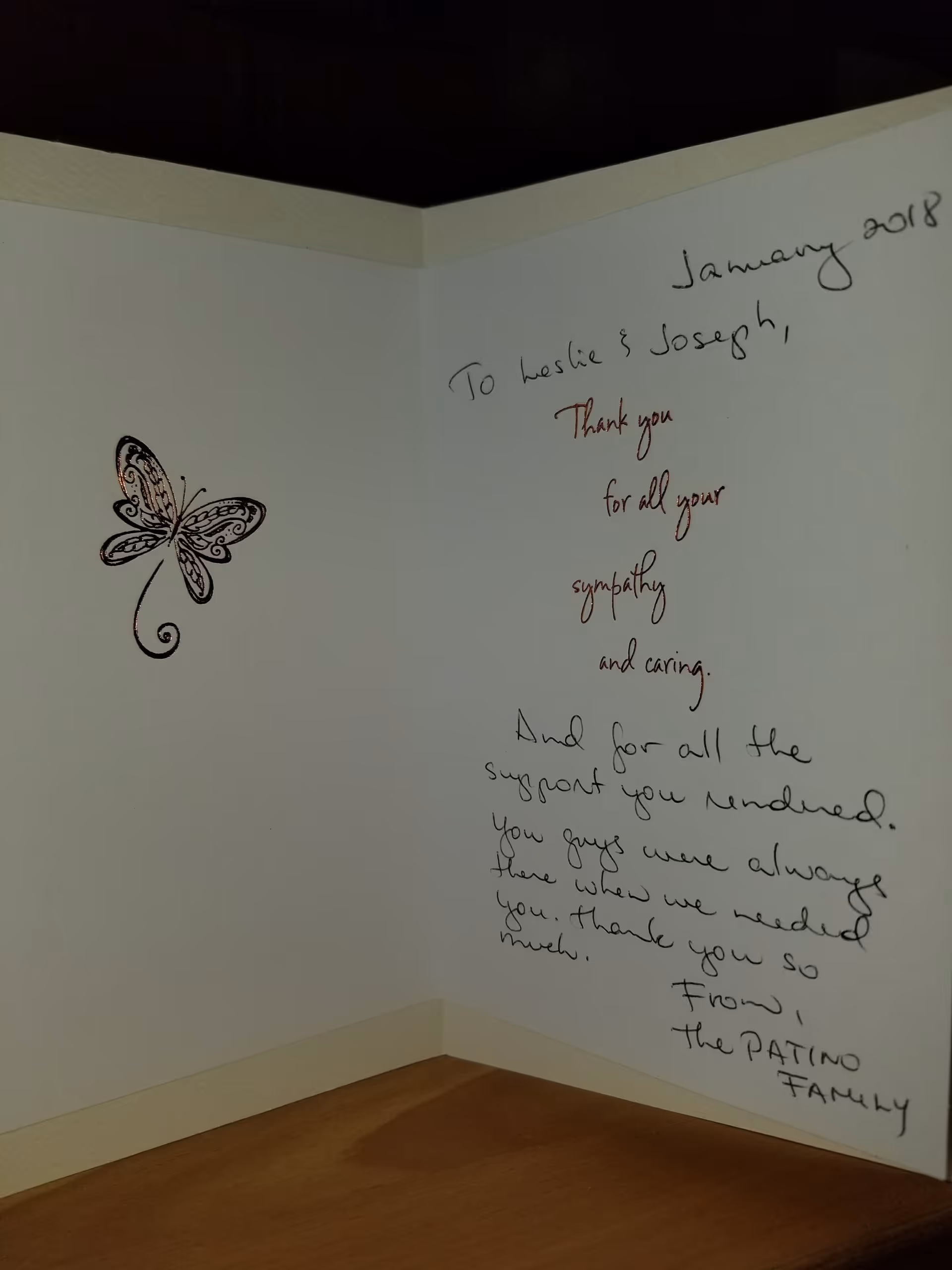 A corner of a room with handwritten messages on the wall and a butterfly decal.