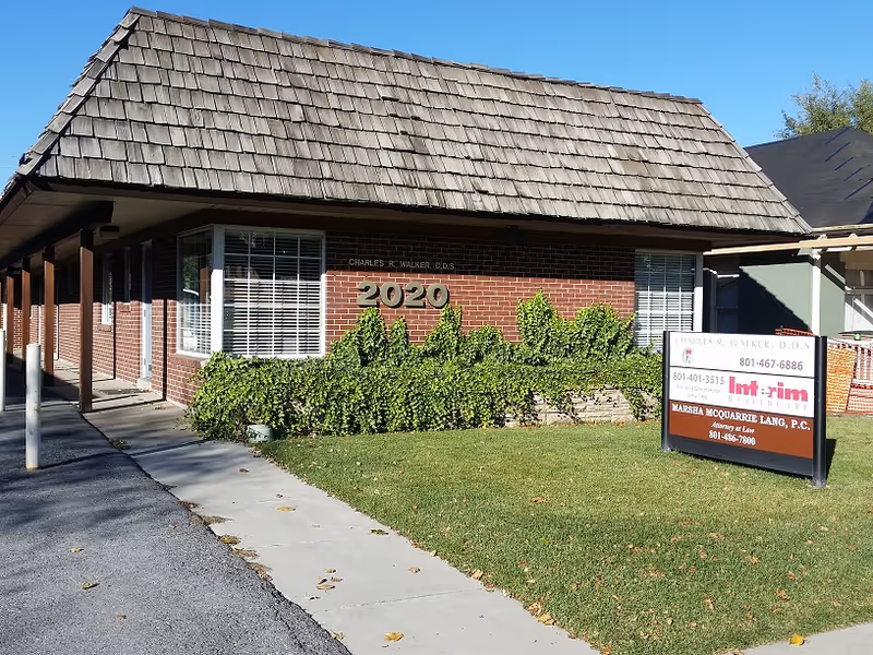 Exterior brick building with a tiled roof, walkway, and a 2020 sign.