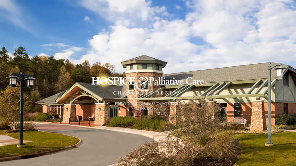 Exterior view of a hospice facility with brick columns and curved driveway.