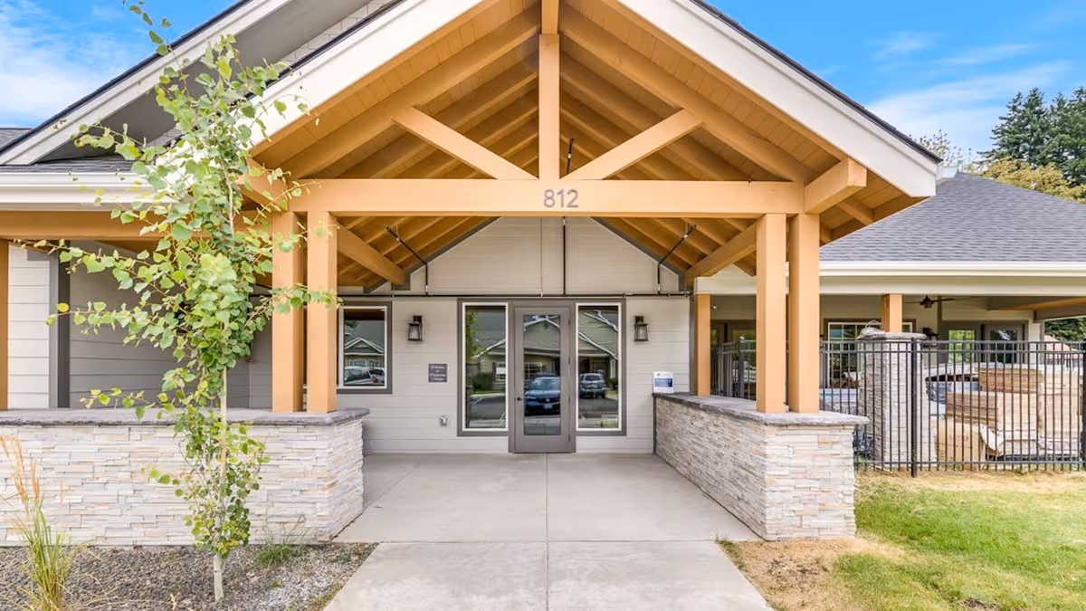 Dalton Senior Living entrance with wooden canopy, glass doors, and stone walls