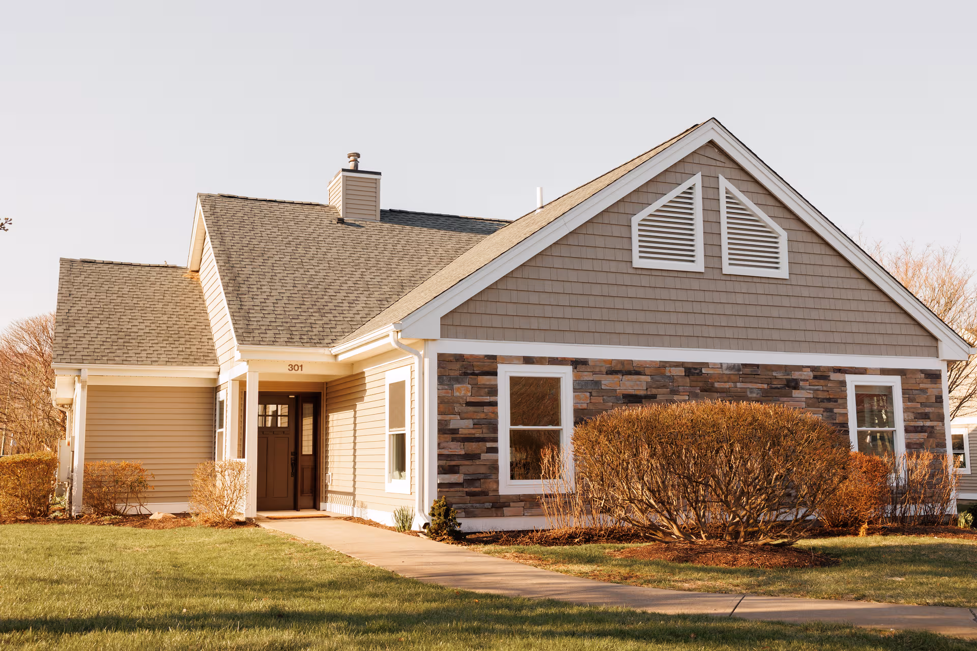 Front exterior view of Seabury Active Life Plan Community building with shrubs and walkway.