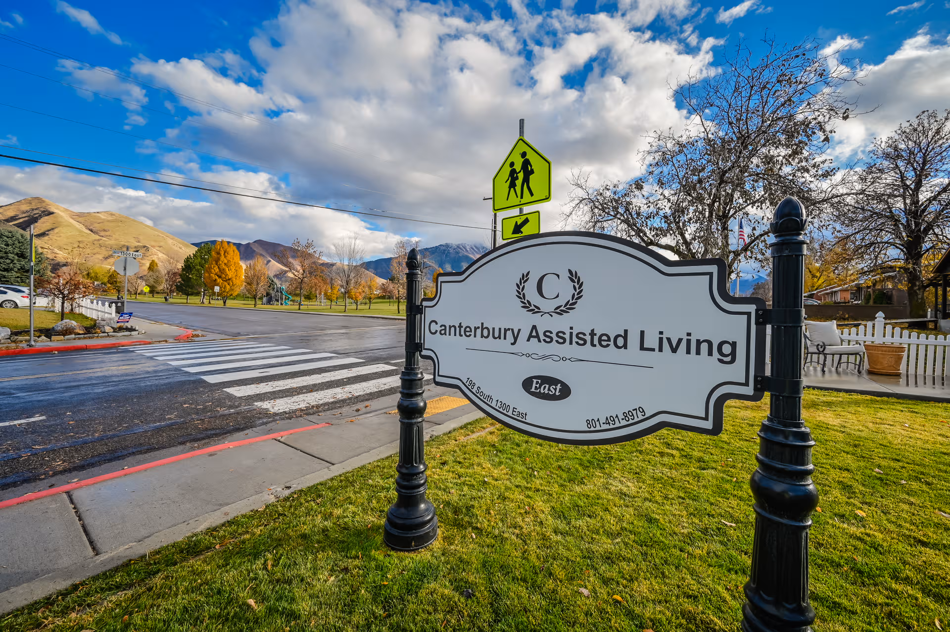 The Canterbury Assisted Living East sign sits at the entrance with a crosswalk and mountains behind.