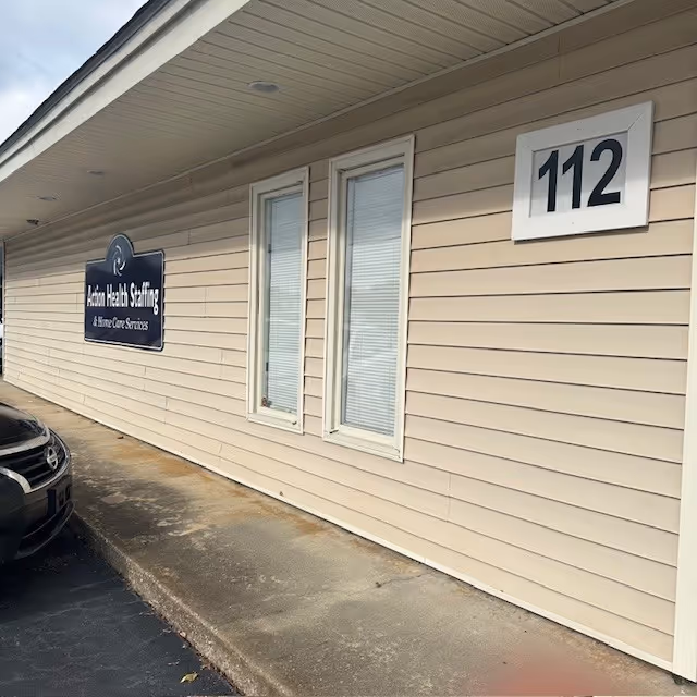 Exterior view of a senior care facility with a blue Action Health Staffing sign.