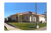 Front exterior of a single-story health care center with lawn, driveway, and a red-tiled roof.