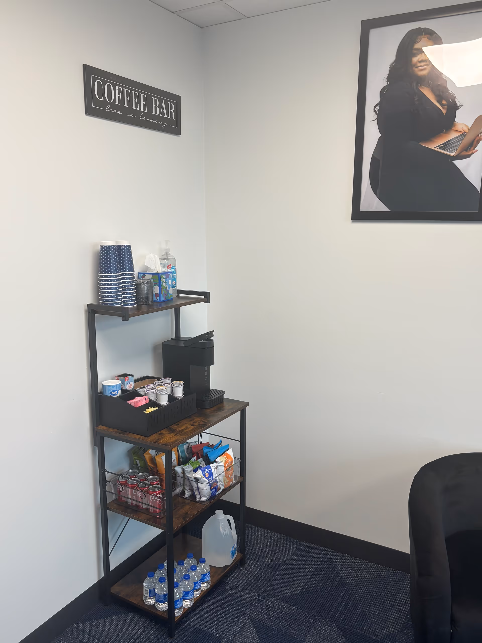 Interior coffee bar with cups, beverages, snacks, and a wall poster.