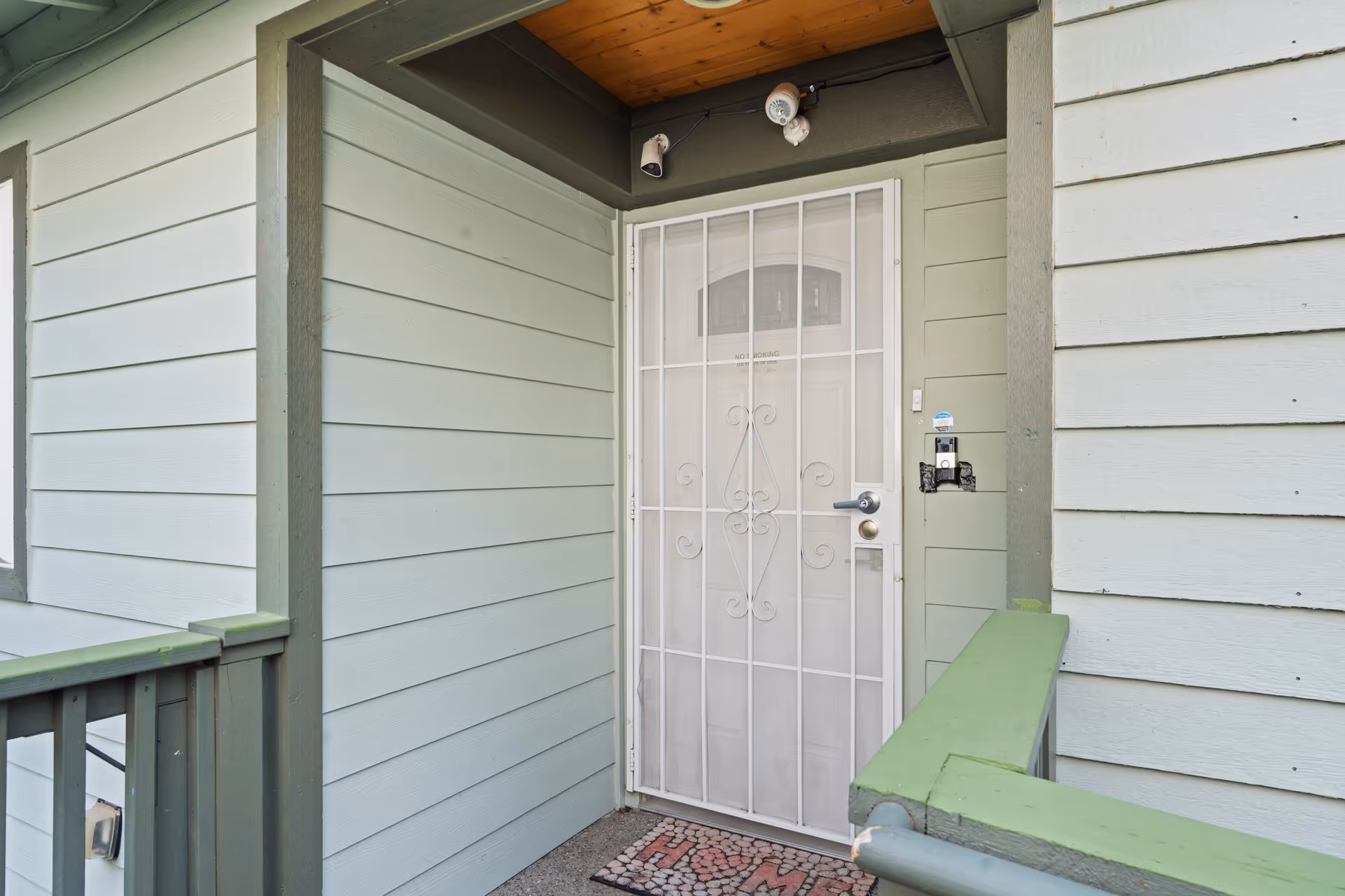 Exterior porch entry to a senior living home with security screen door.