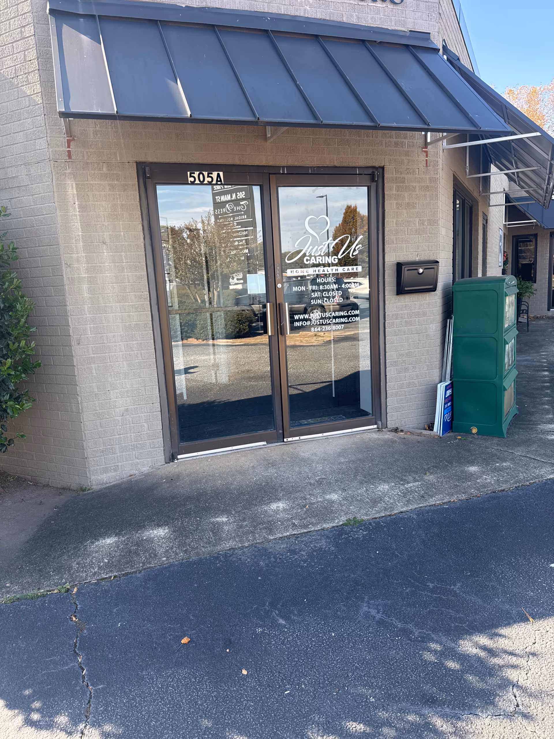 Entrance of Just Us Caring Home Health Care facility with glass doors and canopy.