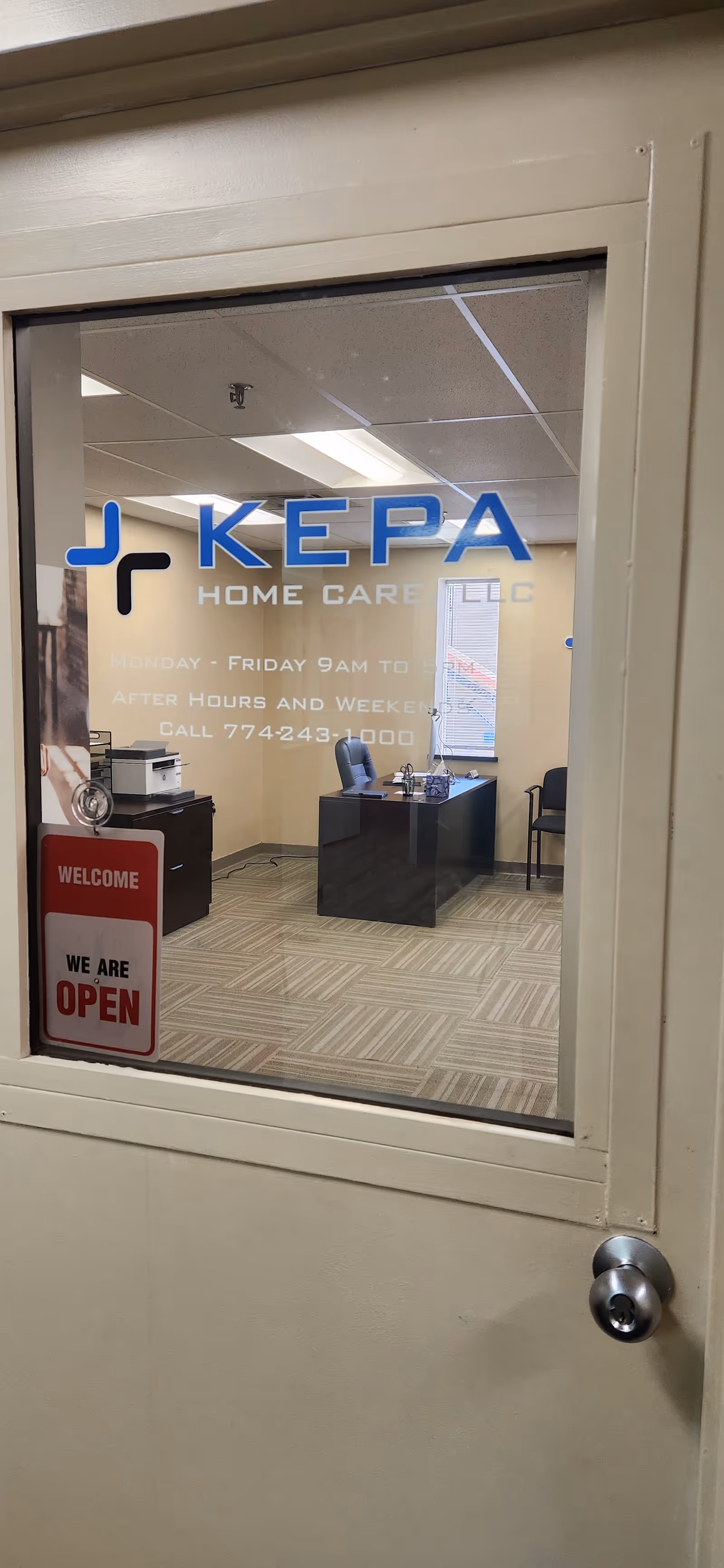 View into KEPA Home Care LLC reception through glass door displaying logo and open sign.