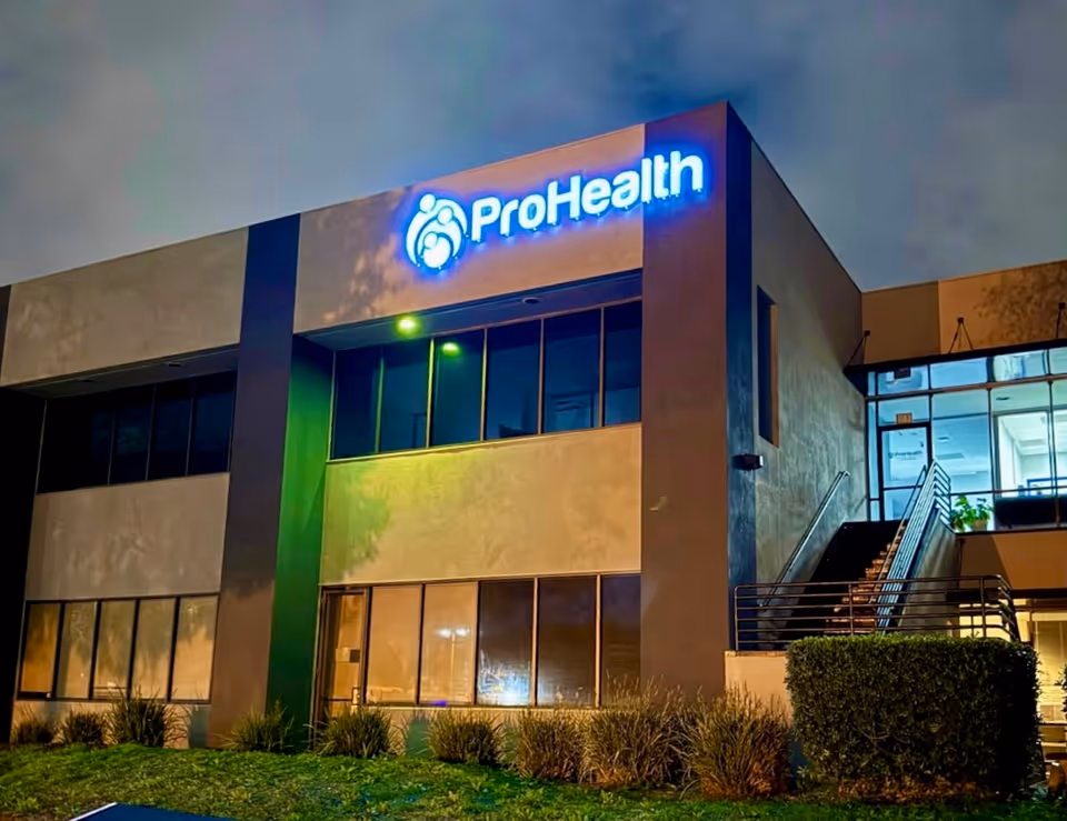 Nighttime exterior view of ProHealth Home Care building with illuminated sign.