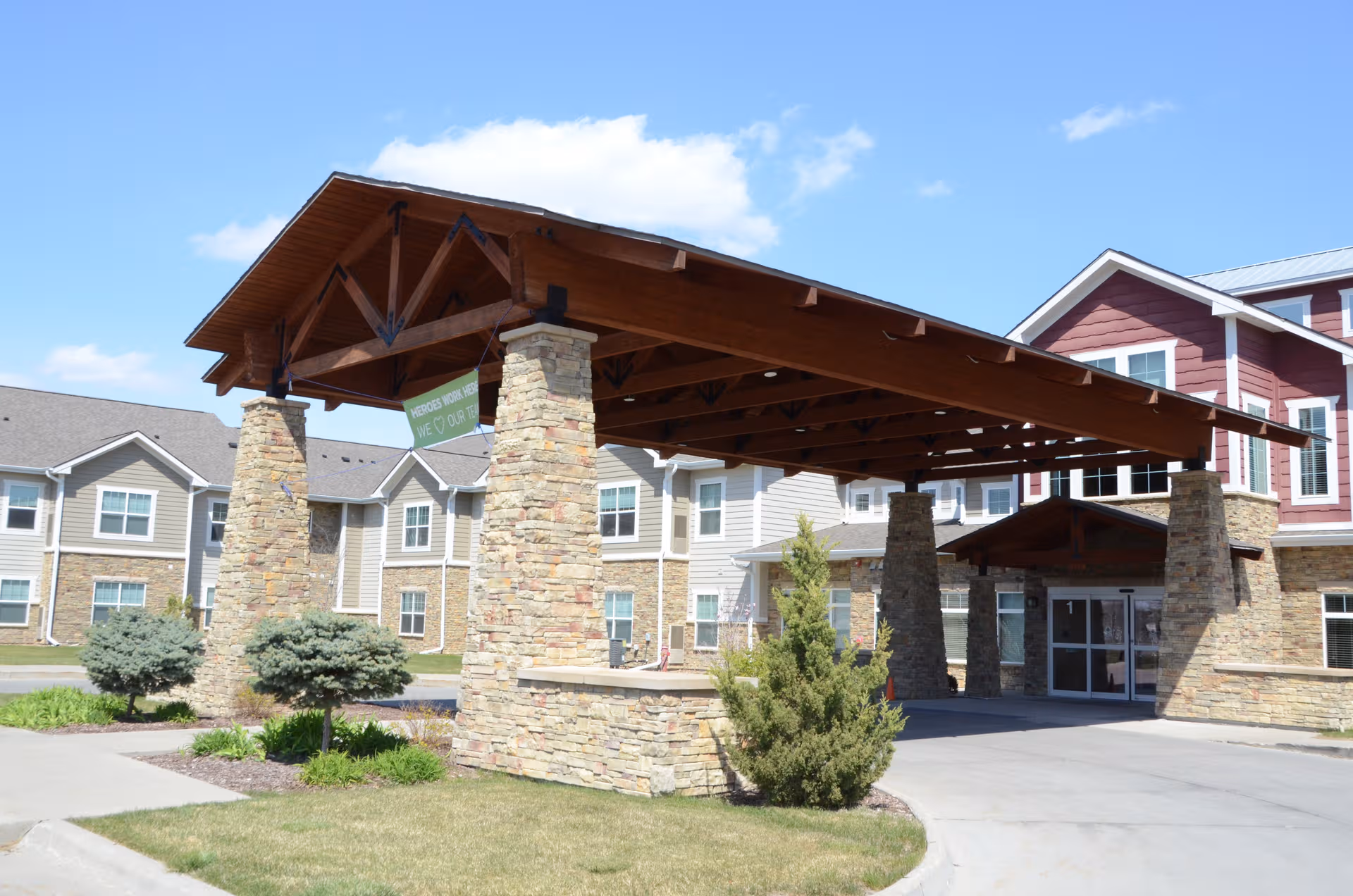 Exterior view of Northridge Village senior living facility with stone pillars and porte-cochere.