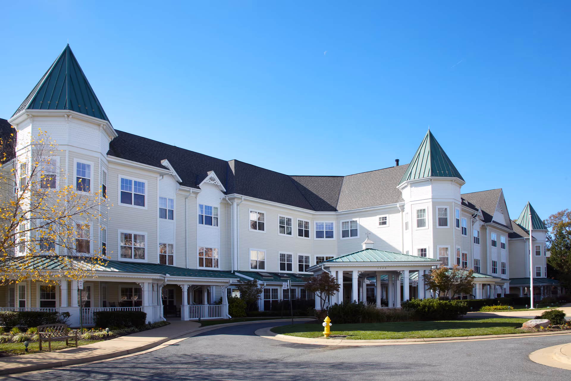 Sunrise of Alexandria exterior senior living building with white siding and green roofs.
