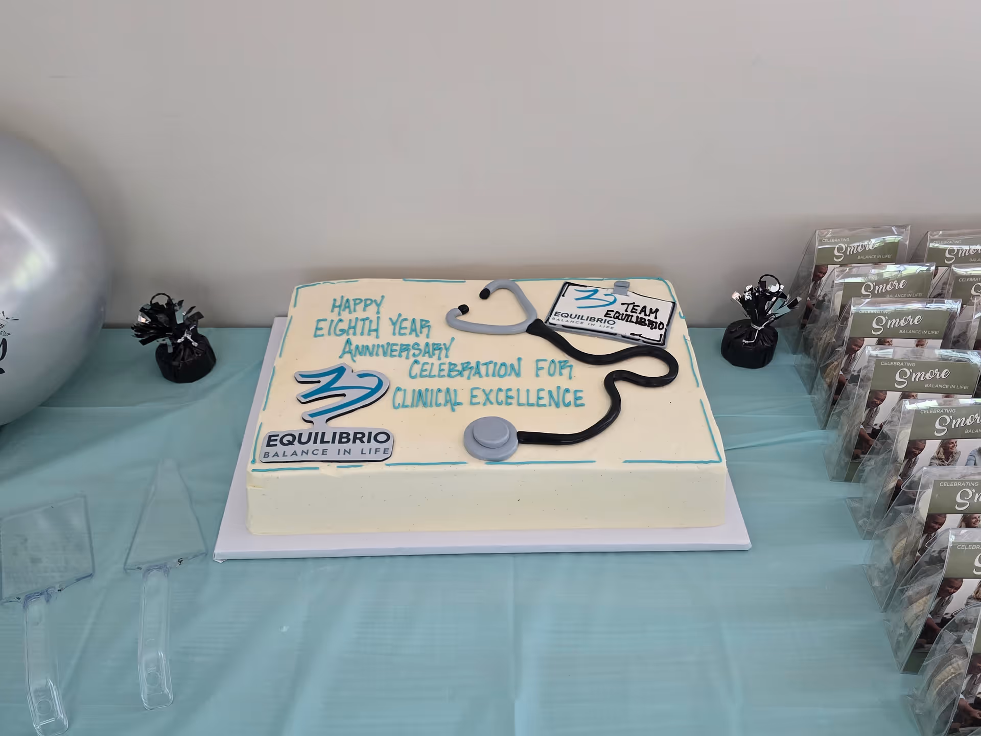 Interior table with anniversary cake and stethoscope decoration for Equilibrio Home Health of Virginia.