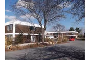 Exterior view of a two-story nursing facility with parking and leafless trees.