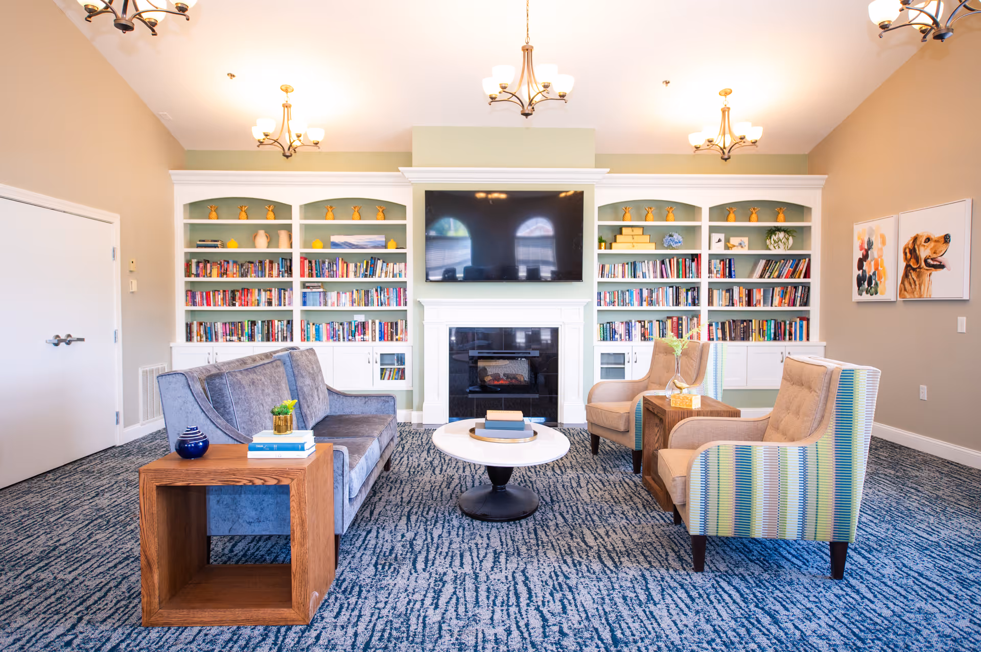Cozy lounge with built-in bookshelves, a fireplace, and comfortable seating.