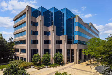 Modern multi-story healthcare facility with glass facade and landscaped entrance.