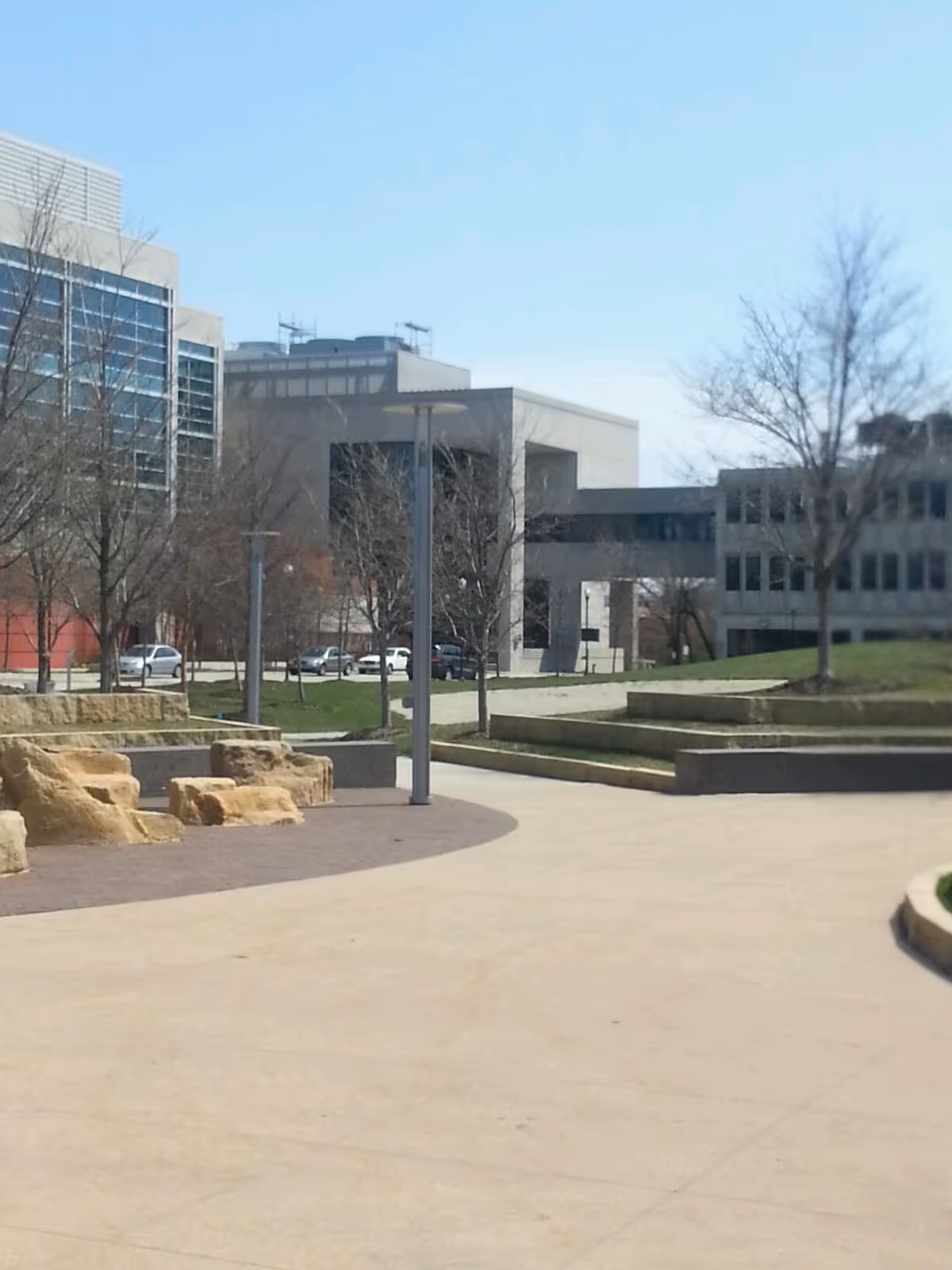 Exterior courtyard of a modern campus building with trees and walkways.
