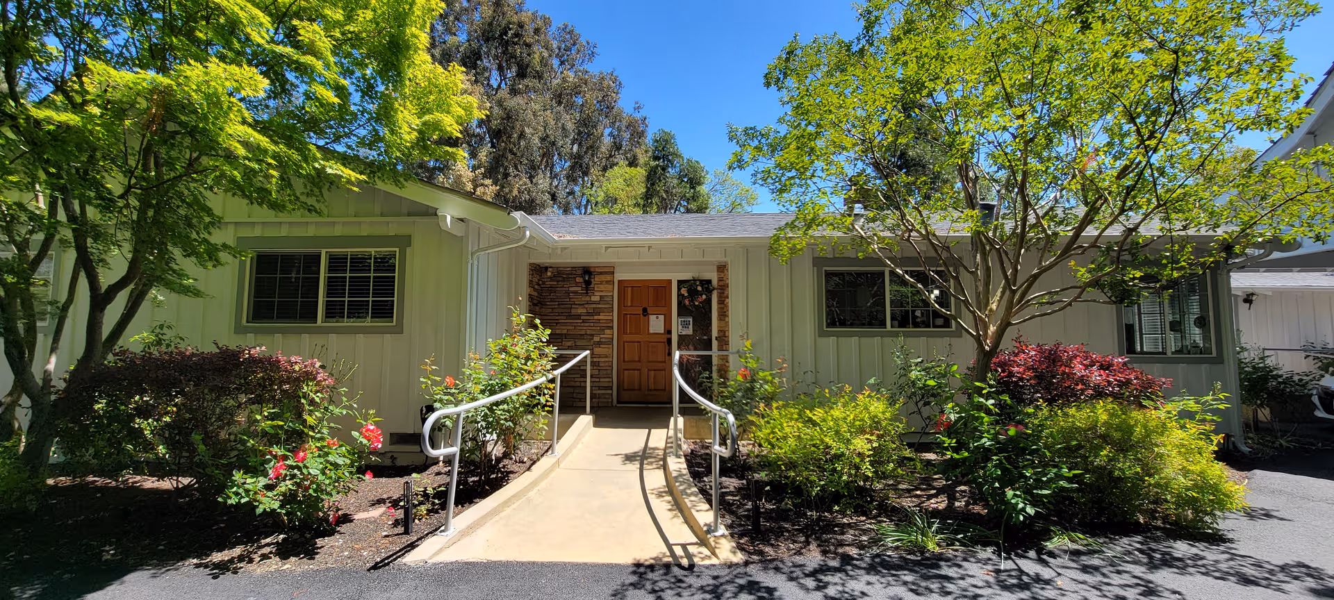 Front exterior of Moraga Retreat Care on Woodford with ramp and greenery.