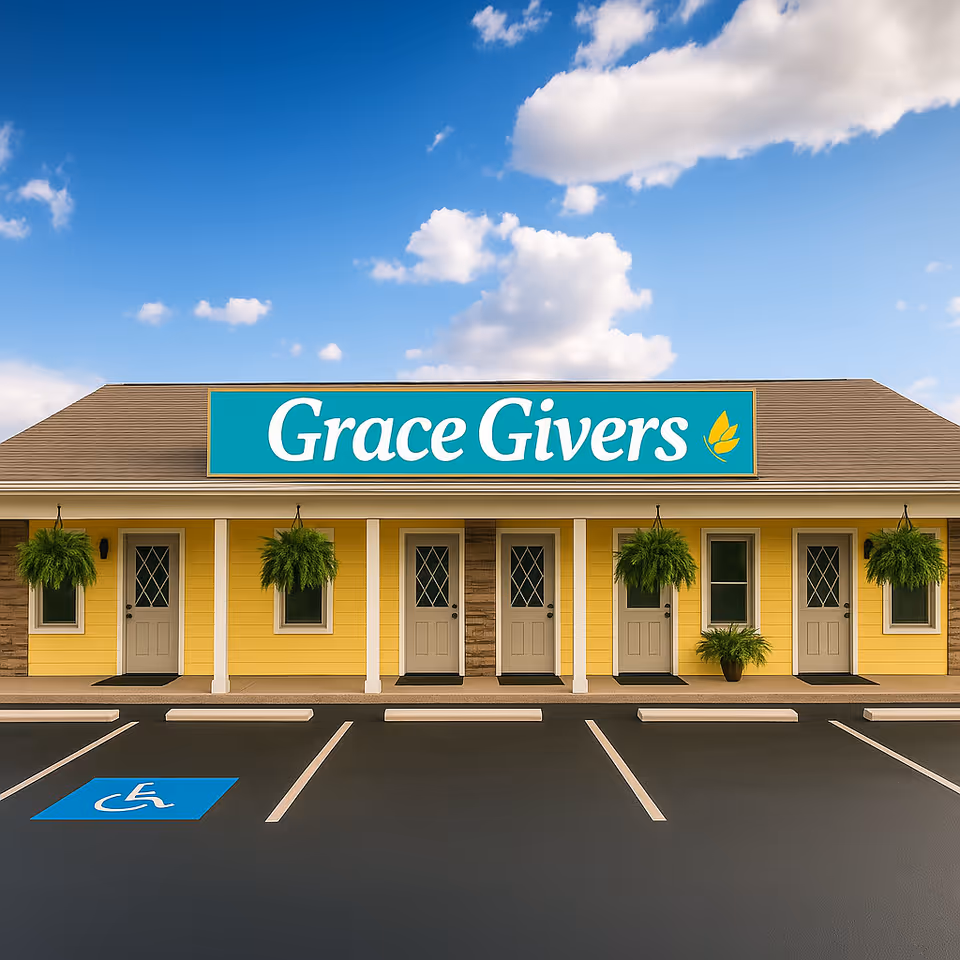 Yellow, single-story building with a large Grace Givers sign and handicap parking.