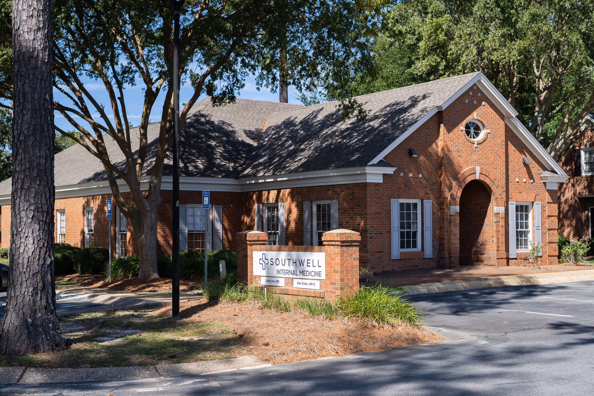 Brick medical clinic with arched entrance and trees, sign says Southwell Internal Medicine.