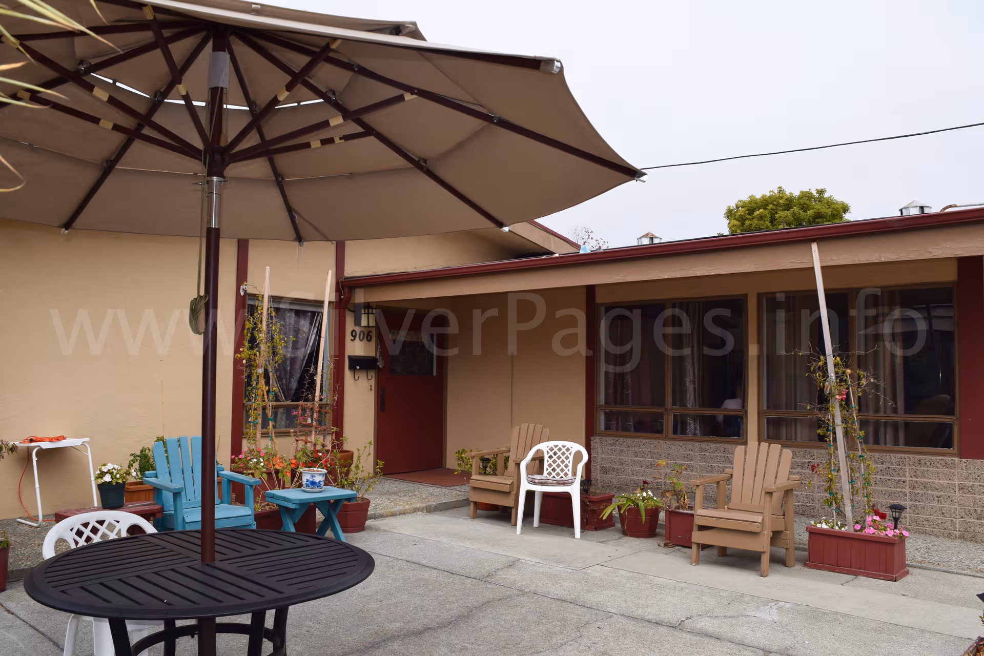 Outdoor patio area of Raksha Care Homes with seating and a large umbrella