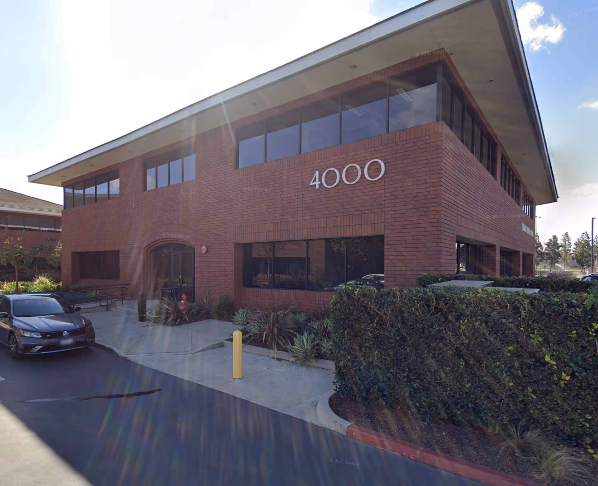 Two-story brick office building with large 4000 address number and parking lot.