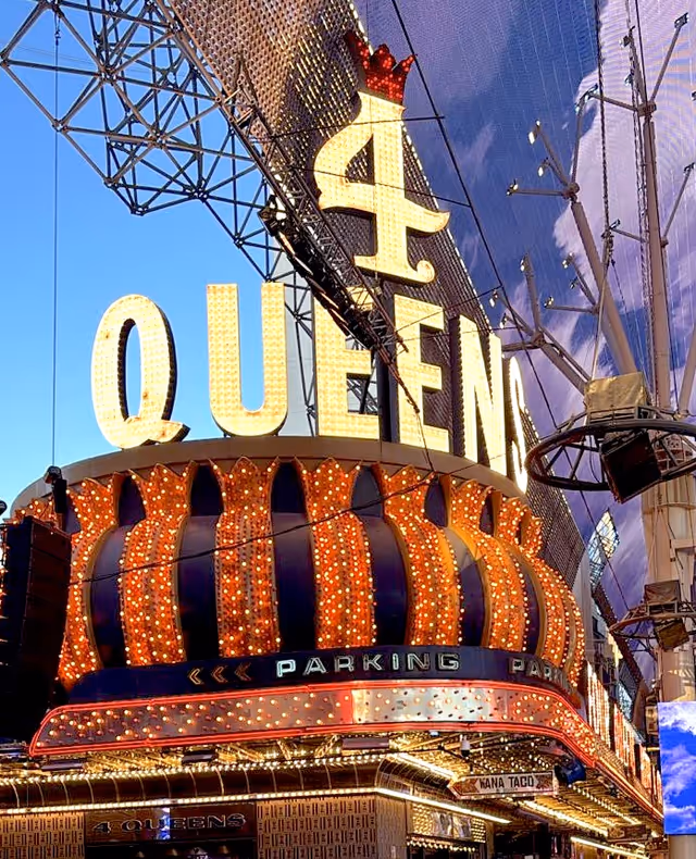 Nighttime exterior of a casino front with a large QUEEN sign.