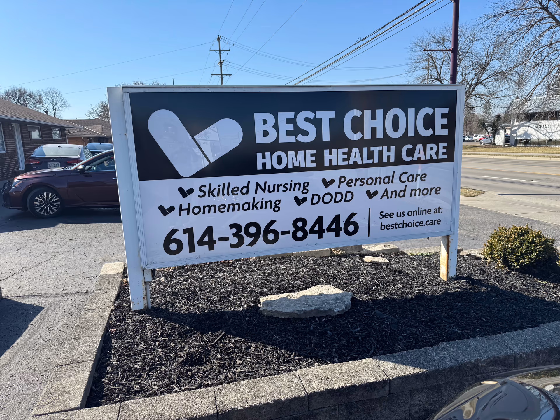 Large outdoor sign reads Best Choice Home Health Care with contact number in a parking lot.