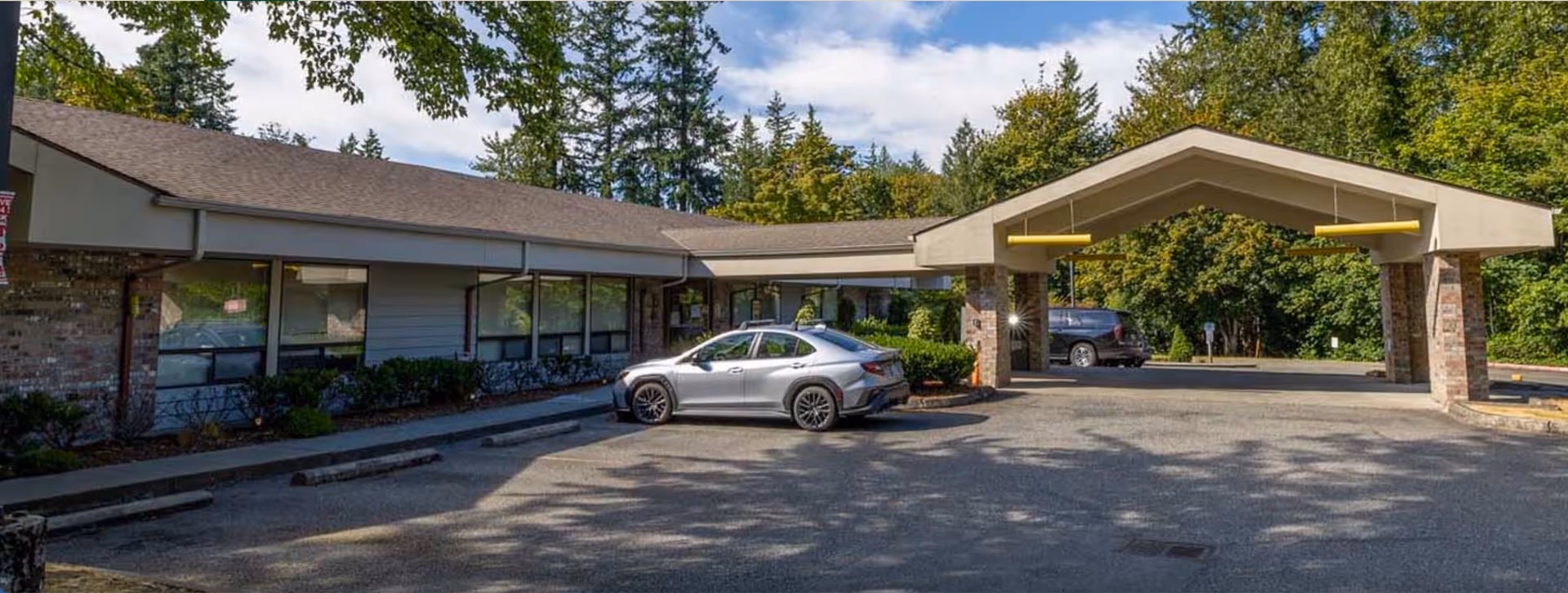 Exterior view of Providence Marianwood facility with a covered entrance and parked cars.