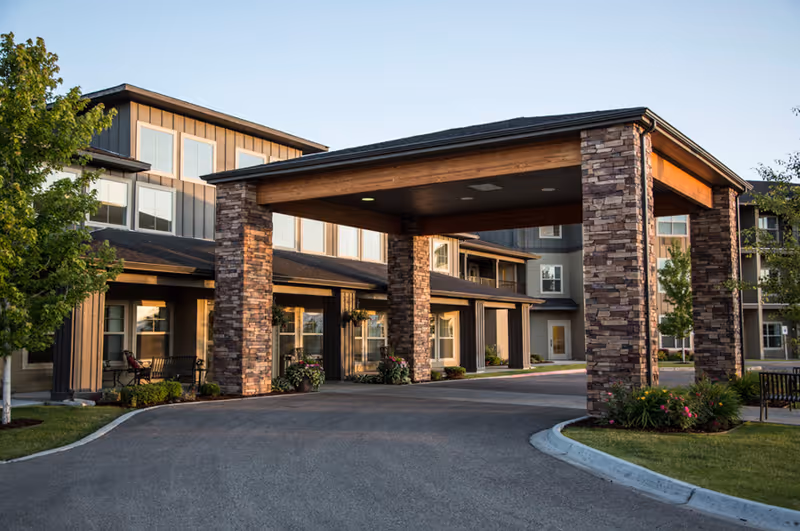 Exterior view of MorningStar Senior Living with a stone-pillared porte-cochère and landscaped entrance.