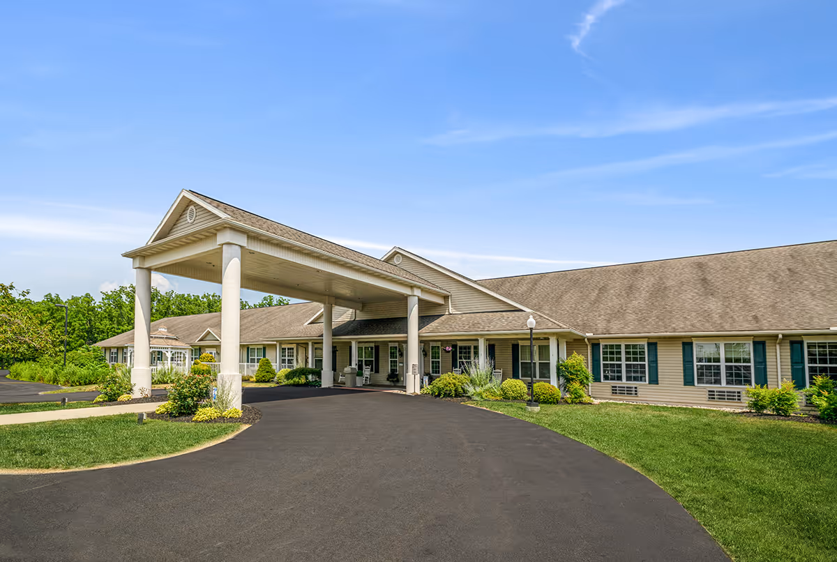 Exterior view of a single-story senior living facility with porte-cochère and curved driveway.